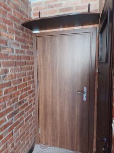 brązowe drzwi hotelowe pod skosem